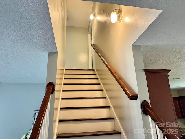 stairs featuring a textured ceiling