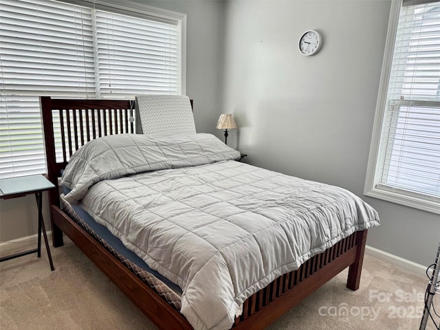 bedroom featuring light carpet and baseboards