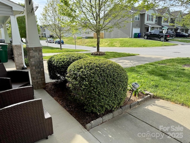 view of yard with a residential view and covered porch