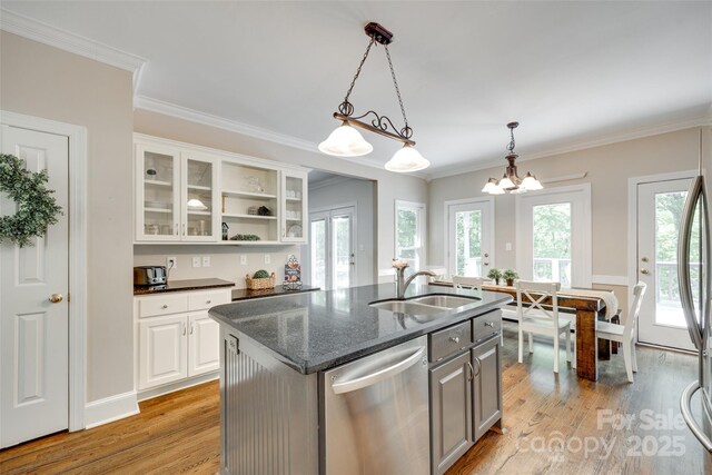 kitchen with a sink, light wood-style floors, dishwasher, white cabinetry, and a center island with sink