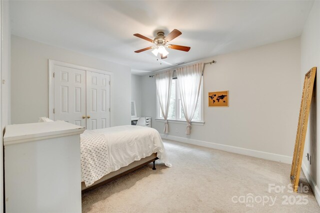 bedroom featuring ceiling fan, light carpet, baseboards, visible vents, and a closet