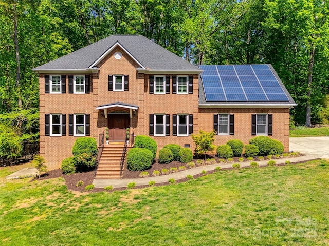 7122 Forest Ridge Rd, Matthews, NC 28104 - colonial home with solar panels, a front lawn, and brick siding