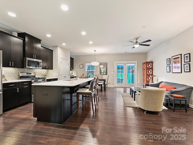 12641 Glowing Peak Rd, Huntersville, NC 28078 - kitchen with dark cabinetry, open floor plan, recessed lighting, and stainless steel appliances