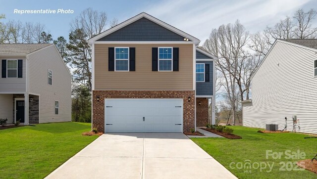 view of front of property with brick siding, a garage, driveway, and a front yard