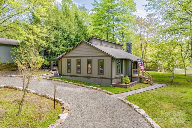 22 Dalonigei Ct, Brevard, NC 28712 - view of front of house with board and batten siding, a front lawn, a chimney, stairs, and roof with shingles