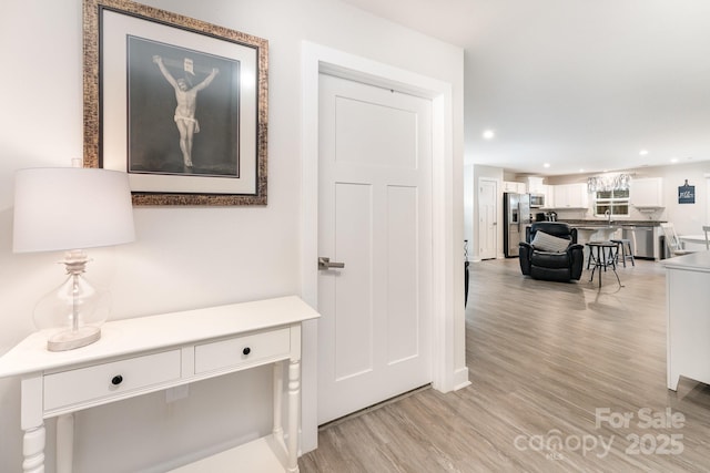 hall with light wood-type flooring and recessed lighting