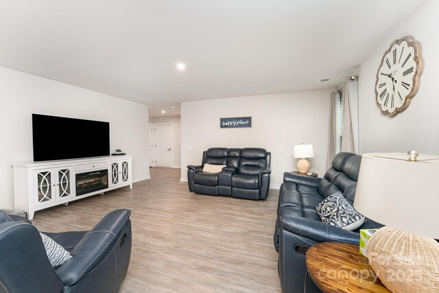 living area featuring baseboards, recessed lighting, and light wood-style floors