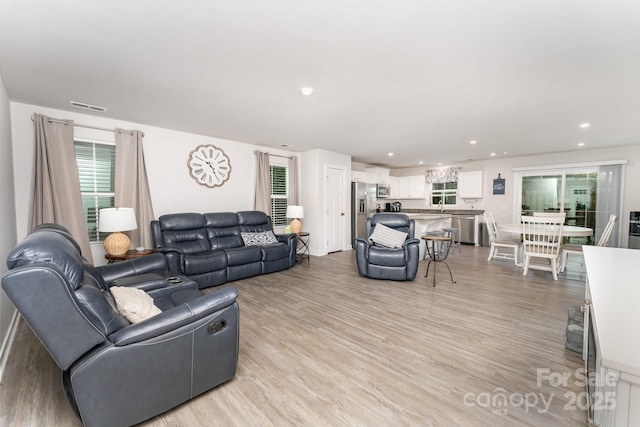 living area featuring visible vents, a wealth of natural light, light wood-style flooring, and recessed lighting