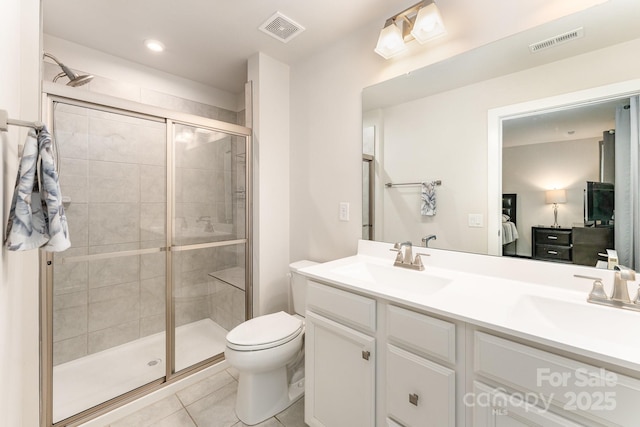 bathroom featuring visible vents, a shower stall, and a sink