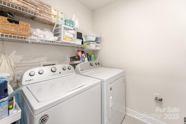 washroom featuring washing machine and clothes dryer, laundry area, and baseboards
