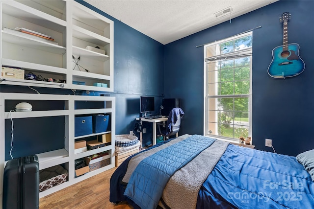 11913 Little Stoney Ct, Charlotte, NC 28269 - bedroom featuring visible vents, a textured ceiling, and wood finished floors