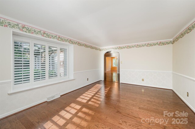 2643 Rolling Hills Dr, Monroe, NC 28110 - spare room with crown molding, wood finished floors, arched walkways, baseboards, and visible vents