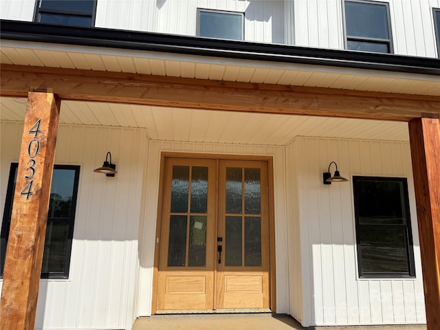 view of exterior entry with a porch and french doors