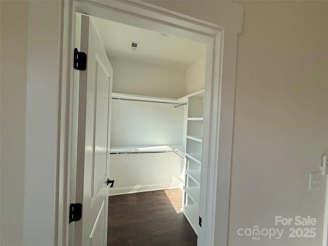 walk in closet with visible vents and dark wood-style floors
