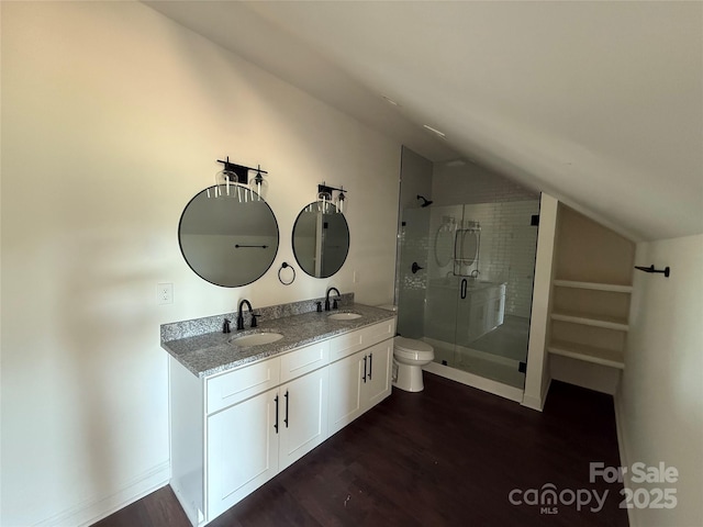 bathroom featuring a shower stall, vaulted ceiling, wood finished floors, and a sink