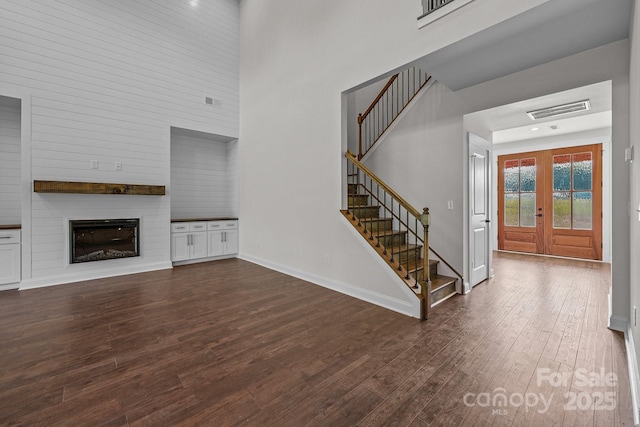 4034 Daugherty Rd, China Grove, NC 28023 - foyer featuring a high ceiling, dark wood-style floors, stairway, a large fireplace, and french doors
