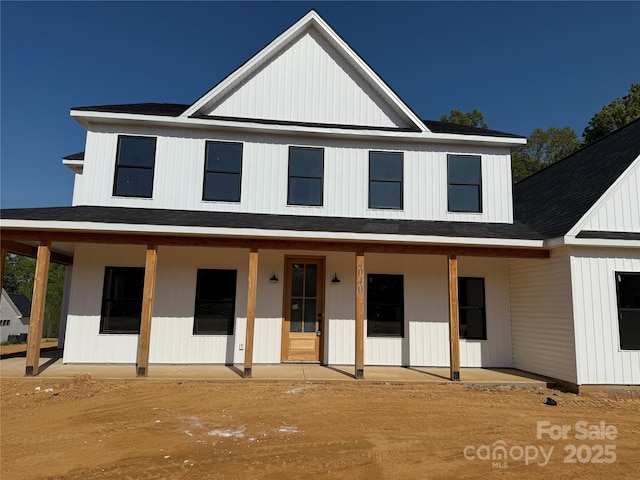 modern inspired farmhouse with roof with shingles and covered porch