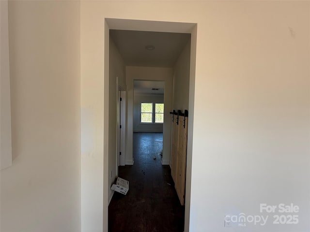hallway with baseboards and dark wood-style flooring