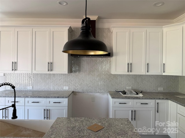 kitchen with dark stone counters, white cabinetry, and tasteful backsplash