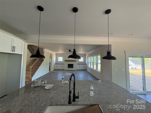 kitchen featuring plenty of natural light, a sink, and crown molding