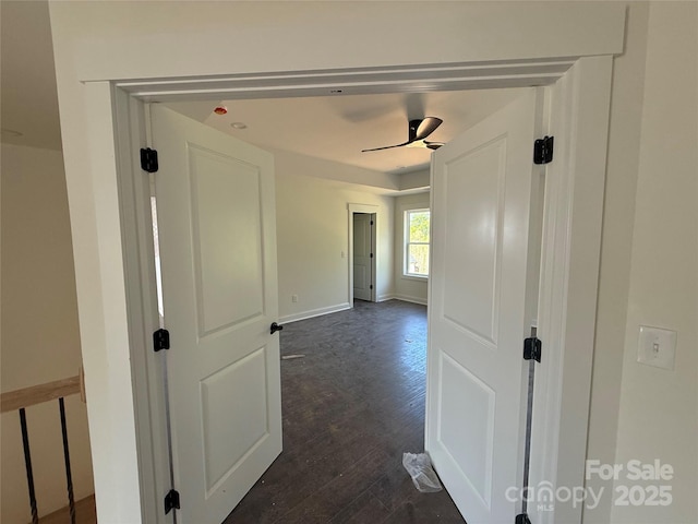 hallway with baseboards and dark wood-type flooring