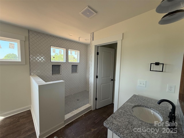 bathroom featuring wood finished floors, visible vents, walk in shower, and a healthy amount of sunlight
