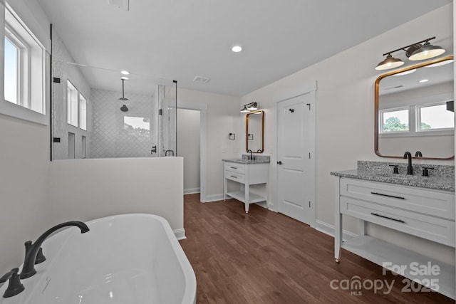 4040 Daugherty Rd, China Grove, NC 28023 - bathroom with a walk in shower, a soaking tub, two vanities, wood finished floors, and recessed lighting