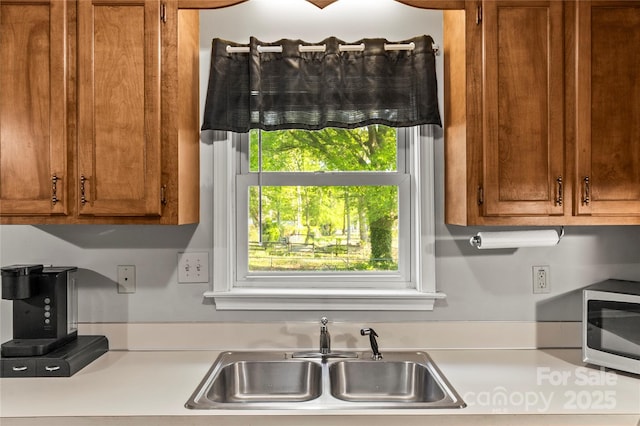 304 W Fourth St, Cherryville, NC 28021 - kitchen featuring light countertops, stainless steel microwave, brown cabinets, and a sink