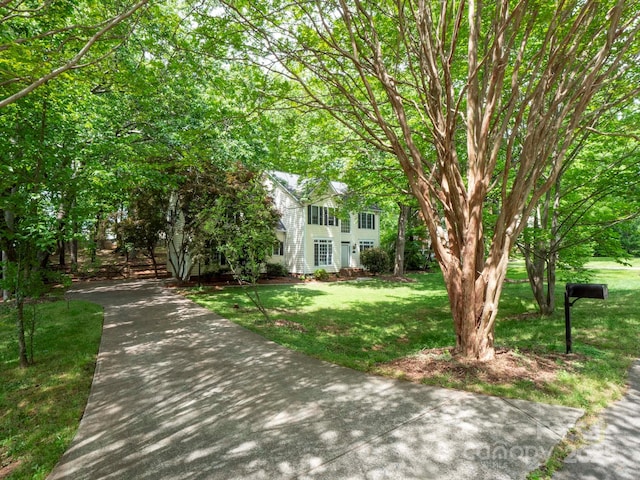 colonial inspired home with a front lawn and driveway