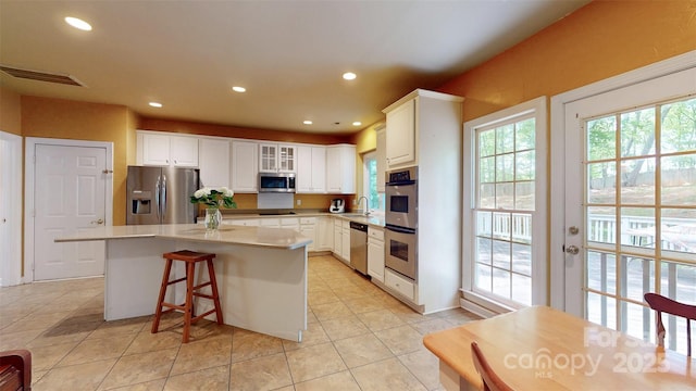 kitchen featuring visible vents, appliances with stainless steel finishes, a kitchen island, and recessed lighting