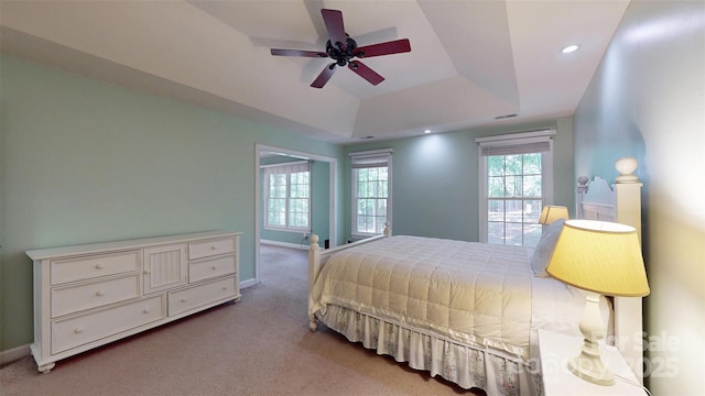 bedroom featuring ceiling fan, a raised ceiling, baseboards, carpet flooring, and visible vents