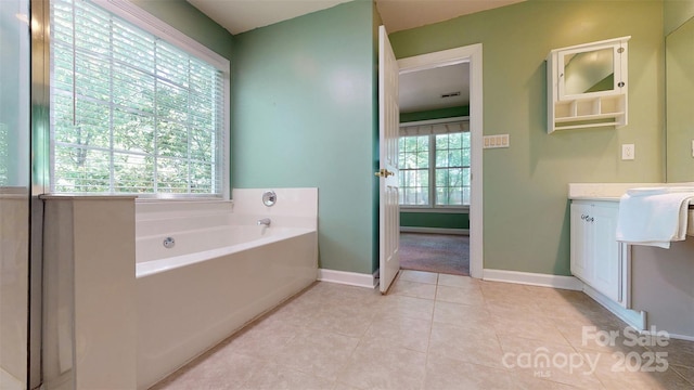 bathroom with baseboards, a garden tub, tile patterned floors, and vanity
