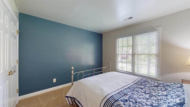 bedroom with carpet floors, visible vents, and baseboards