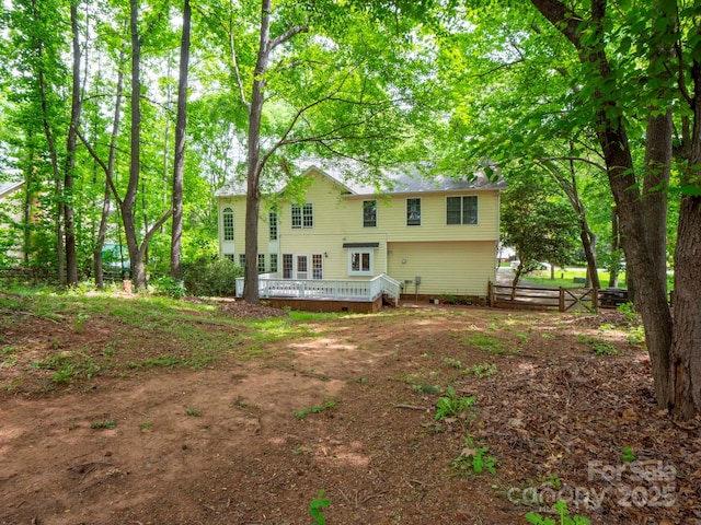 rear view of house featuring fence, a deck, and crawl space