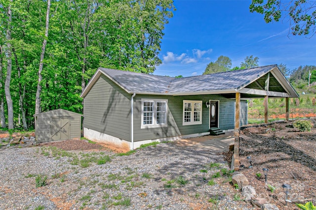 115 Cold Springs Dr, Mill Spring, NC 28756 - view of front facade with metal roof, an outbuilding, a storage unit, and entry steps