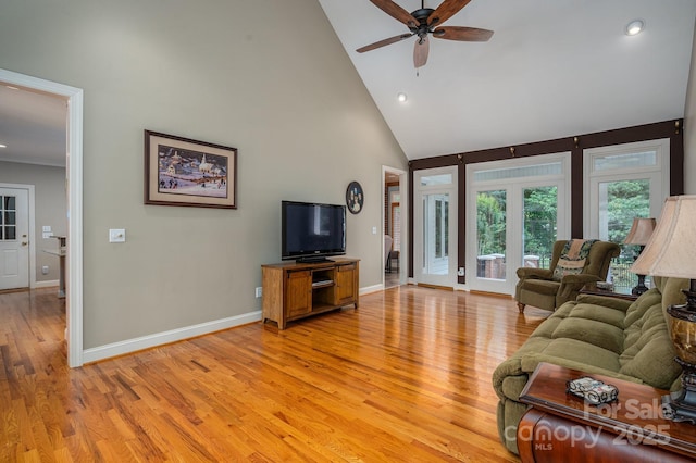 living area with high vaulted ceiling, light wood finished floors, ceiling fan, baseboards, and recessed lighting