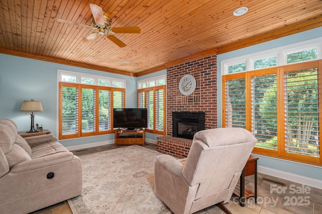 living area with crown molding, baseboards, a ceiling fan, plenty of natural light, and a brick fireplace