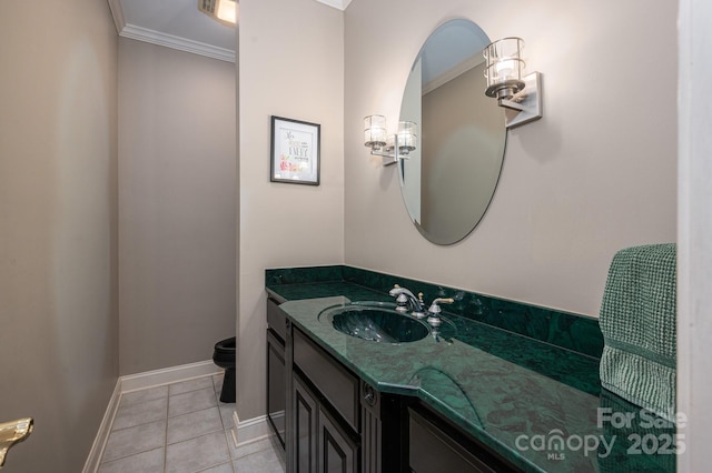 bathroom featuring crown molding, vanity, baseboards, tile patterned floors, and toilet