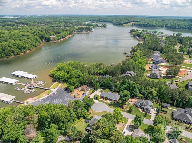 view of property location with a large body of water and a heavily wooded area