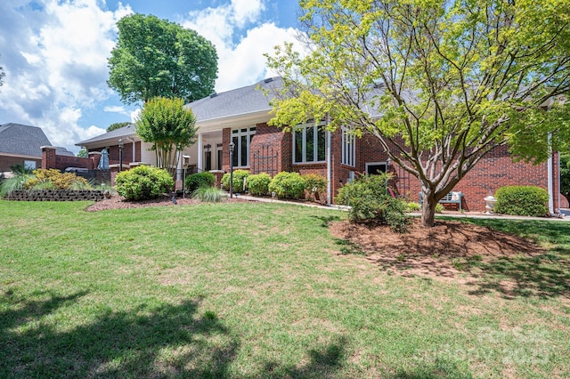 view of front facade with a front lawn and brick siding