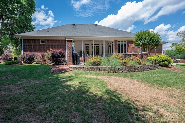 back of house with brick siding, a yard, and central air condition unit