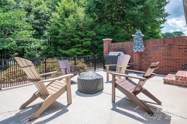 view of patio / terrace with an outdoor fire pit and fence