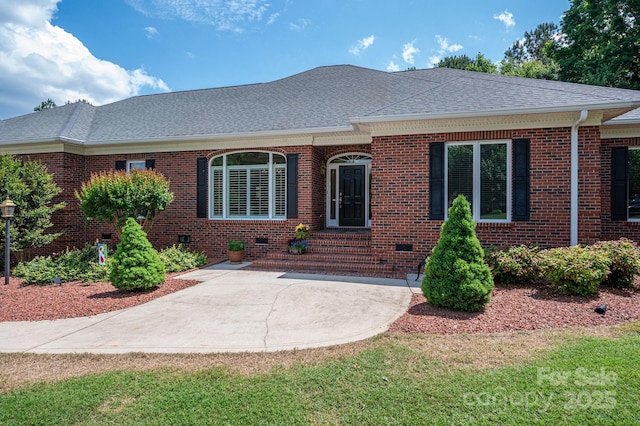 view of front of property with a shingled roof, brick siding, and crawl space