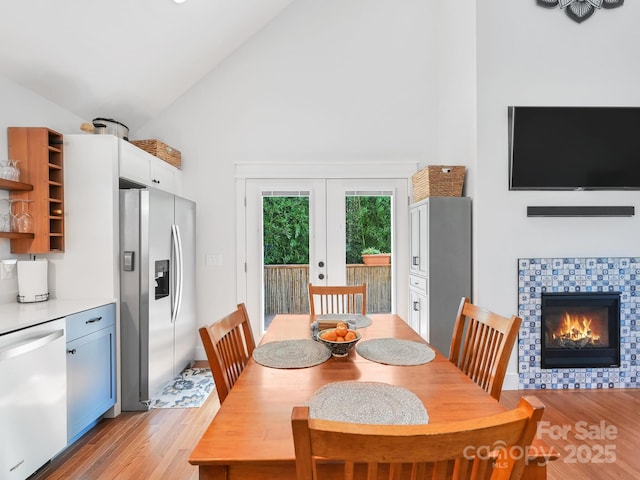 18 Covington St, Asheville, NC 28806 - dining space with high vaulted ceiling, french doors, light wood-style floors, and a tiled fireplace