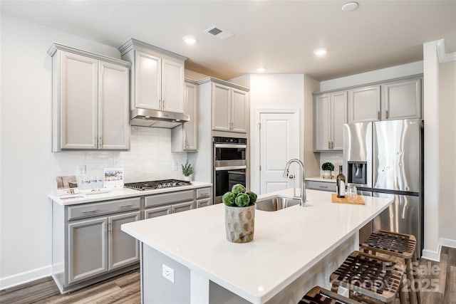 13210 Kenworth Rd, Charlotte, NC 28278 - kitchen featuring gray cabinets, stainless steel appliances, a kitchen breakfast bar, wood finished floors, and recessed lighting
