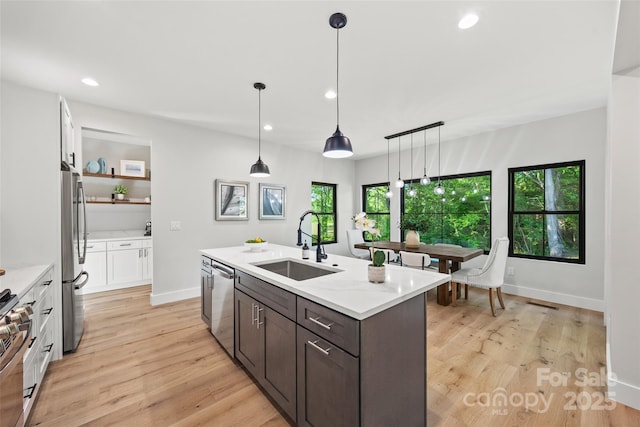1 Linestowe Dr, Belmont, NC 28012 - kitchen featuring a sink, light wood-type flooring, a center island with sink, appliances with stainless steel finishes, and white cabinetry