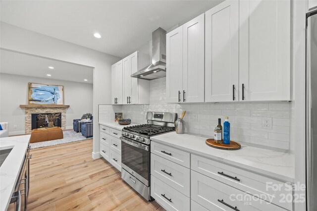1 Linestowe Dr, Belmont, NC 28012 - kitchen with white cabinets, stainless steel gas stove, backsplash, wall chimney exhaust hood, and light wood-style flooring