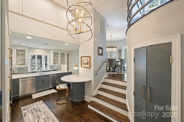 423 N Pine St, Charlotte, NC 28202 - bar with a high ceiling, a notable chandelier, a sink, dark wood-type flooring, and stainless steel dishwasher