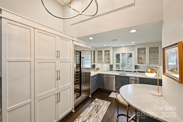 423 N Pine St, Charlotte, NC 28202 - kitchen with appliances with stainless steel finishes, a sink, white cabinetry, dark wood-style floors, and glass insert cabinets