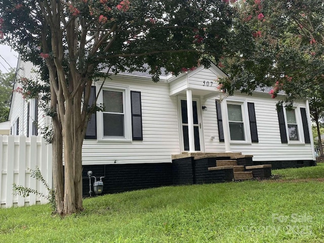 view of front facade with fence, crawl space, and a front yard